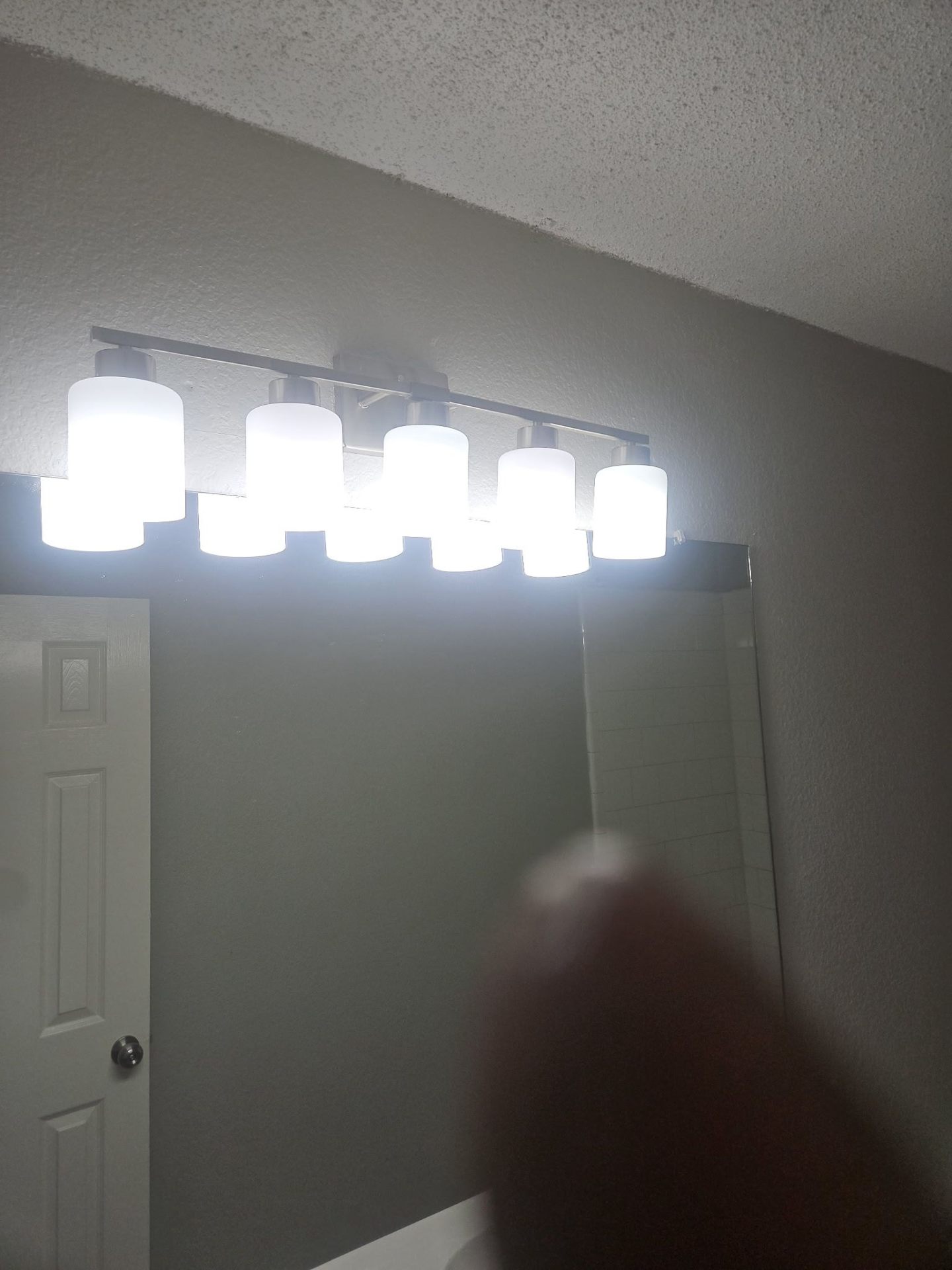 Installed five-bulb vanity light fixture above a bathroom mirror